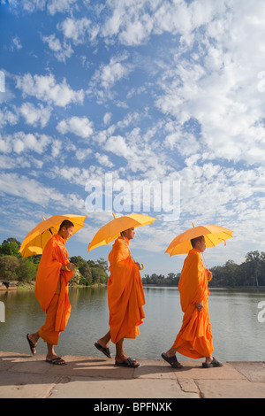 Trois moines par les douves entourant l'ensemble du Temple d'Angkor Wat, Siem Reap, Cambodge, Asie du sud-est Banque D'Images
