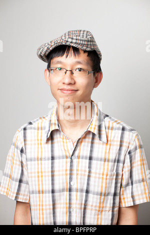 Portrait d'un jeune homme avec une expression agréable portant une casquette à carreaux et une chemise à carreaux Banque D'Images