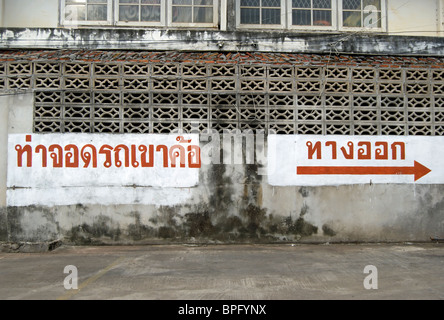 Signe de langue thaï dans un parking à phetchabun, Thaïlande, Asie du Sud-Est, en indiquant 'car park' (gauche) et 'way out' (droite) Banque D'Images
