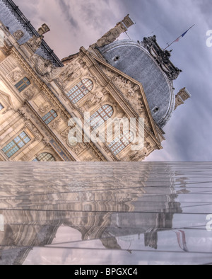 Le Louvre reflète d'I.M. Pyramide de Pei, comme les nuages se rassemblent au-dessus. L'un des murs de la pyramide forme un faux horizon. Banque D'Images