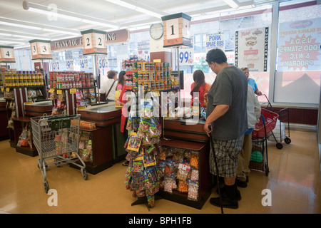 Shoppers au check-out les caissières dans un supermarché dans le New York Banque D'Images