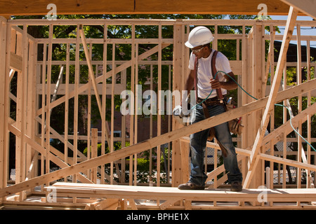 Carpenter standing at a construction site tenant un pistolet de scellement Banque D'Images