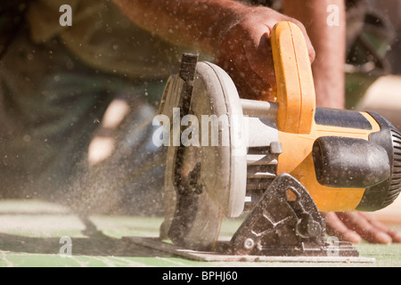 Carpenter en utilisant une scie circulaire sur un site de construction Banque D'Images