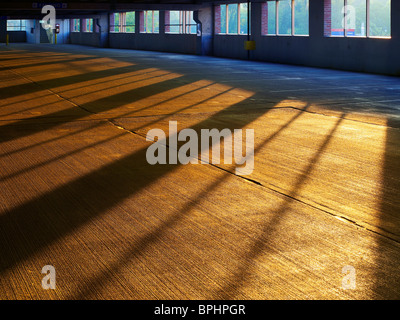 Lever tôt le matin et les ombres du soleil sur béton gravé dans un garage vide, Philadelphia, USA Banque D'Images