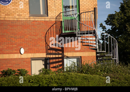 Un escalier de secours en colimaçon avec ombres sur la construction à Poole Banque D'Images