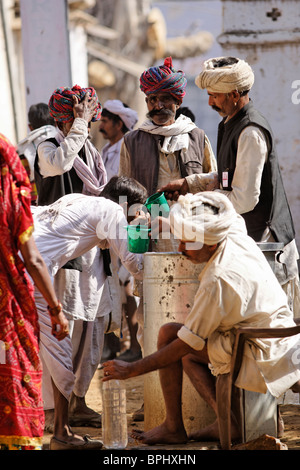 Les pèlerins de l'eau potable à Pushkar, Rajasthan Inde. Banque D'Images