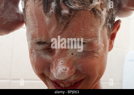 Un adolescent ses cheveux Shampooing Banque D'Images