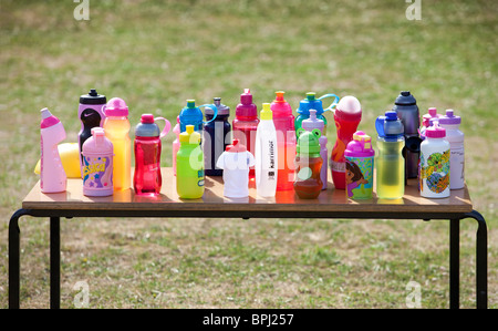 Des rangées de bouteilles de boisson de couleur de l'enfant sur une table. Banque D'Images