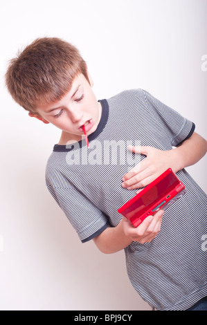 Un modèle a publié la photo d'un garçon de 10 ans de jouer avec une console de jeux portable Nintendo DS dans le studio Banque D'Images