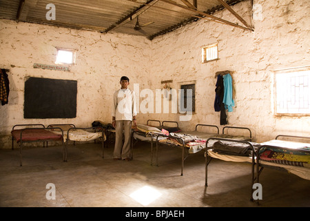 Un jeune montre l'hébergement dans l'internat pour enfants dans tribal Sasan dans l'État de Gujarat, en Inde. Banque D'Images