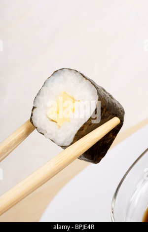 Baguettes en bois tenant un morceau de sushi. Avec l'exemplaire de l'espace. Focus sélectif. Banque D'Images