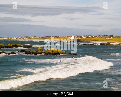 Nobla Porth, conseil informatique, de l'île d'Anglesey, dans le Nord du Pays de Galles, Royaume-Uni. Vagues se brisant sur un jour de vent des surfeurs dans l'eau Banque D'Images