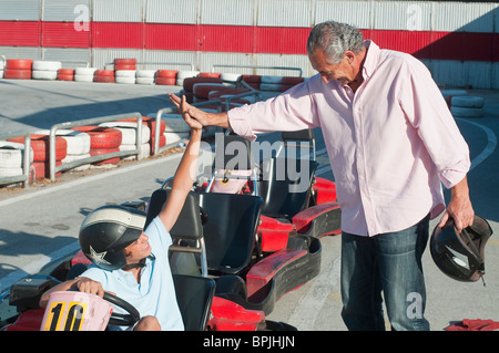Grand-père et petit-fils d'origine hispanique sur piste de karting Banque D'Images