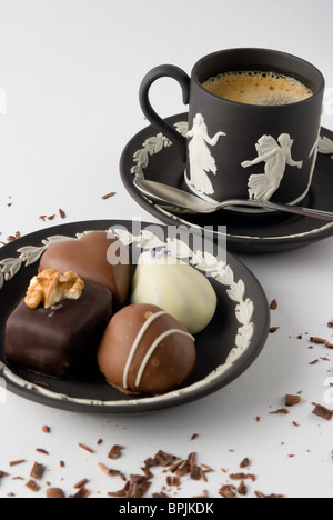 Chocolats présentés sur une plaque avec une tasse de café en arrière-plan Banque D'Images