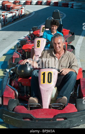 Grand-père et petit-fils d'origine hispanique sur piste de karting Banque D'Images