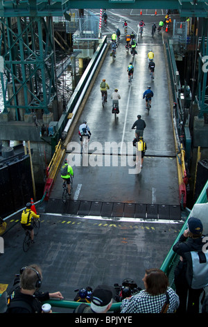 Seattle les navetteurs cyclistes quittent le ferry tôt le matin comme marcher sur les passagers regarder et attendre leur tour pour débarquer. Banque D'Images