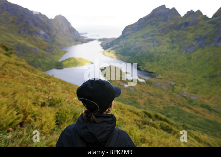 Jeune femme à Agvatnet au lac entouré de montagnes, Lofoten, Norway, Scandinavia, Europe Banque D'Images