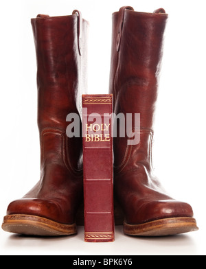 Paire de bottes avec la sainte bible isolés contre fond blanc Banque D'Images