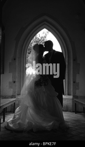 Mariée et le marié en noir et blanc sur jour de mariage à l'église de la porte Banque D'Images