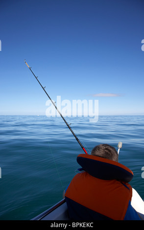 10 year old woman holding gilet de pêche à la canne à pêche en mer en Irlande du Nord uk Banque D'Images