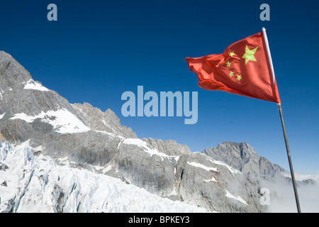 De brandir le drapeau national de la Chine au Dragon de Jade (Yulong Snow Mountain) dans la région de Lijiang, Yunnan Province, China. Banque D'Images