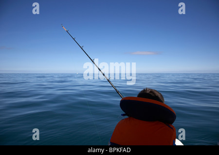 10 year old woman holding gilet de pêche à la canne à pêche en mer en Irlande du Nord uk Banque D'Images