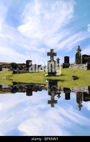 Un vieux cimetière irlandais dans le Kerry sur la côte ouest de l'Irlande reflétée dans l'eau Banque D'Images