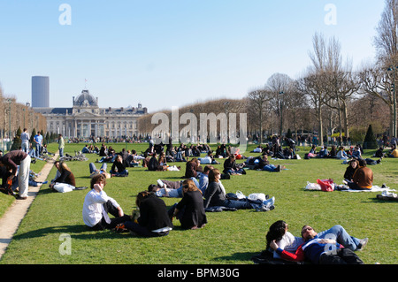 PARIS, France - Les personnes bénéficiant du soleil d'un matin de printemps dans le parc du Champs de Mars à côté de la Tour Eiffel Banque D'Images