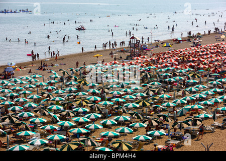 Le tourisme de masse dans la plage de Caorle, Mer Adriatique, Italie. Des milliers de chaises longues et parasols de plage, des parasols. Banque D'Images