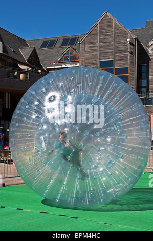 Un jeune garçon "zorbing" ' ' d'une gigantesque bulle en plastique Banque D'Images