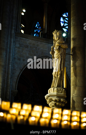 Notre Dame de Paris Madone et statue de l'enfant bougies votives Paris France // PARIS, France — les bougies votives illuminent la Vierge du pilier (Vierge du pilier) statue de la Vierge du pilier et de l'enfant à l'intérieur de notre Dame de Paris. Cette sculpture vénérée est un objet de dévotion important au sein de la cathédrale catholique médiévale. Notre Dame de Paris est largement reconnue pour son architecture gothique emblématique et ses vitraux complexes. La construction de cet important monument a commencé en 1163 et a été en grande partie achevée en 1345. La cathédrale est située sur l'Île de la Cité, au cœur de Paris, en France. Banque D'Images