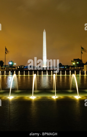 Fontaine du National World War II Memorial la nuit Washington DC // WASHINGTON DC — la fontaine illuminée du National World War II Memorial sur le National Mall la nuit. La fontaine, élément central du mémorial, se reflète magnifiquement sur l'eau calme, créant une scène nocturne sereine et poignante honorant ceux qui ont servi pendant la seconde Guerre mondiale Banque D'Images