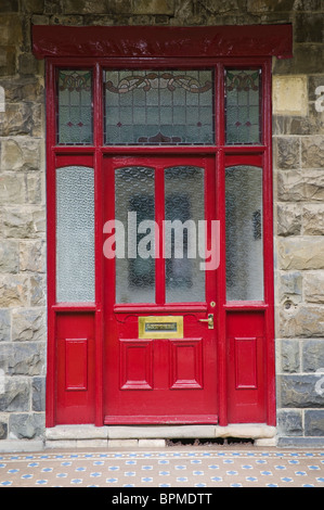 Tôlée et vitrée victorien peint rouge et de l'encadrement de porte avant de maison en pierre à Llandrindod Wells Powys Pays de Galles UK Banque D'Images