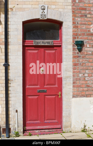 Lambris peint victorien rouge devant la porte d'entrée de maison en brique à Llandrindod Wells Powys Pays de Galles UK Banque D'Images