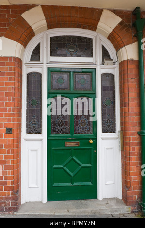 Boiseries victoriennes porte avant peint en vert avec des vitraux de brique construit chambre à Llandrindod Wells Powys Pays de Galles UK Banque D'Images