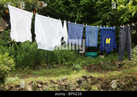 Un travailleur agricole's vêtements de travail suspendu à un lave-ligne dans une basse-cour jardin Banque D'Images
