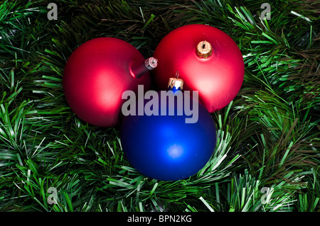 Bombettes rouge et bleu sur fond vert de la chaîne de Noël Banque D'Images