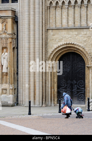 Femme sans-abri en passant devant la cathédrale avec ses affaires. Banque D'Images