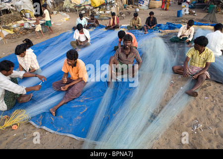 Les pêcheurs indiens sont en train de préparer les filets de pêche tôt le matin sur la plage du village de pêcheurs à Puri, Orissa, Inde. Banque D'Images