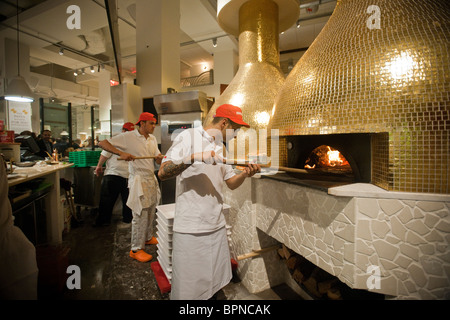 Les ouvriers effectuent pizzas à Eataly la nourriture italienne artisanale et marché du vin à New York Banque D'Images