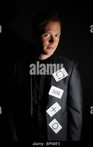 Jeune homme blanc magicien avec ginger hair posant avec symbole cartes à jouer dans studio Banque D'Images