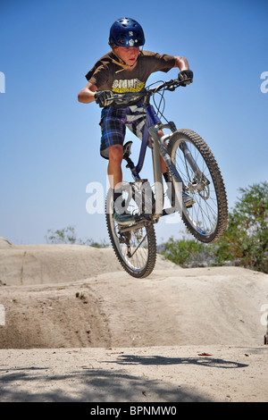 Équitation et vtt bmx Oakley à la piste dirt jump Banque D'Images