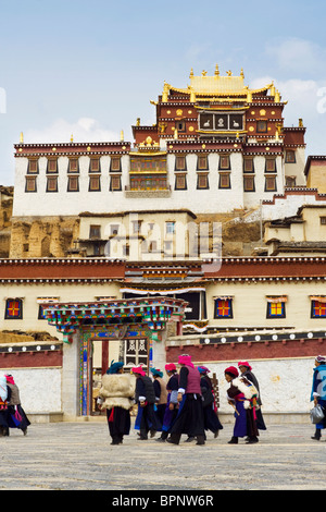 Femme de la région de passer une journée de travail au-delà du monastère tibétain songzanlin, shangri-la, (Zhongdian - Diqing), Yunnan, Chine Banque D'Images