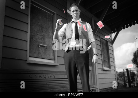 Jeune homme blanc diffusion magicien cartes à jouer à l'extérieur en gare désaffectée Banque D'Images