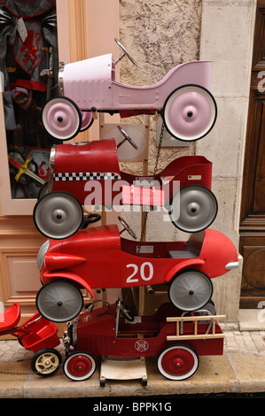 Pile de tin toy ride-sur les voitures à l'extérieur d'un magasin de jouets Banque D'Images