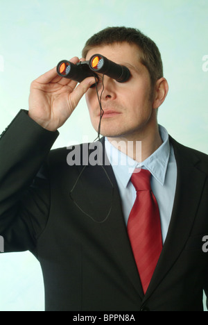 Homme en costume binoculars Banque D'Images