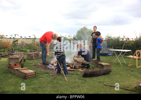 Pères et fils d'allumer un feu de joie. Banque D'Images