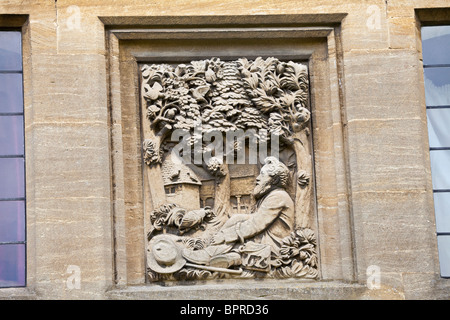 Bas-relief sculpture de William Morris à laisser à un chalet mur dans le village de Cotswold Kelmscott, Oxfordshire. Banque D'Images