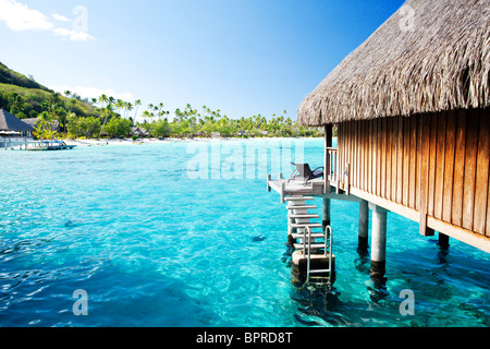 Bungalow sur l'eau avec des marches en incroyable lagon bleu Banque D'Images