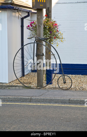 Penny Farthing location verrouillé sur un poteau télégraphique Banque D'Images